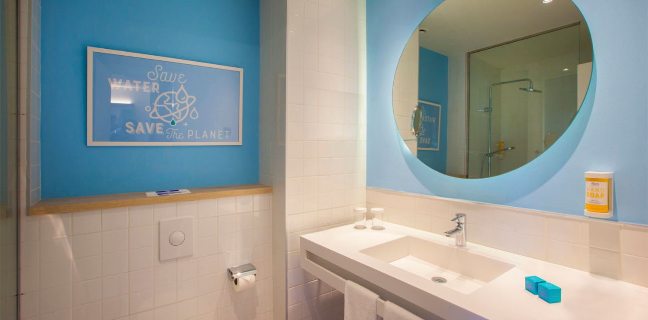 Baño con lavabo y espejo redondo iluminado
