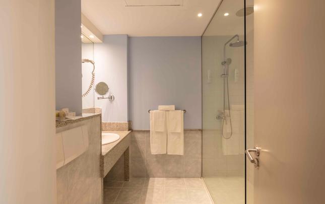 Baño con lavabo y ducha con mampara